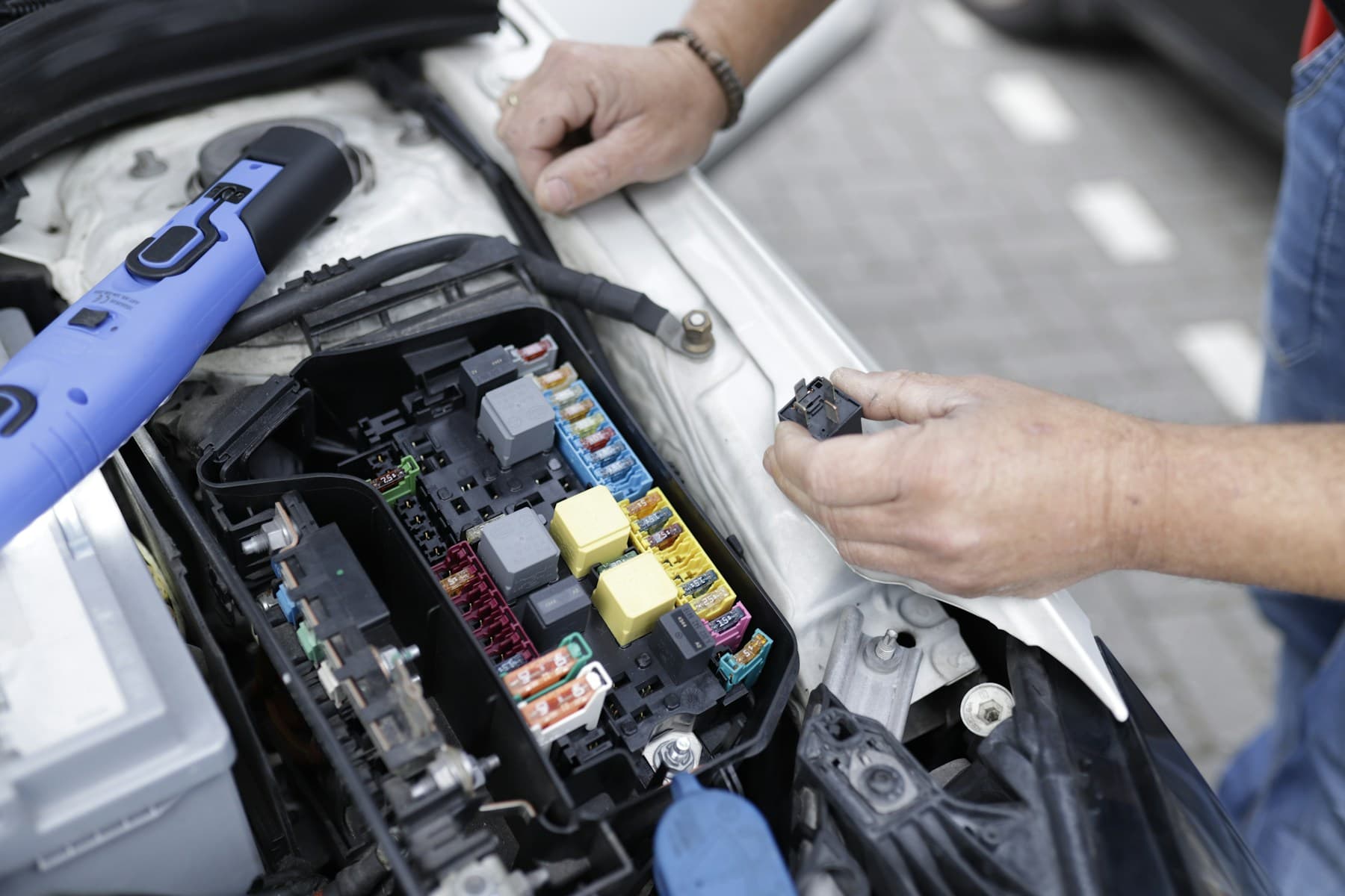 Mechanic checking vehicle electrical components during mobile service